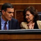 El presidente del Gobierno, Pedro Sánchez, conversa con la vicepresidenta, Carmen Calvo, durante un pleno del Congreso.