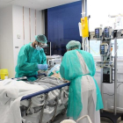 Dos sanitaris atenent un pacient a l’hospital de Trueta de Girona.
