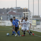 Un jugador de l’Alcarràs protegeix la pilota, perseguida per dos futbolistes del Borges.