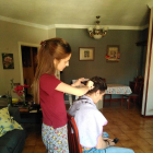Una jove tallant els cabells al seu pare a casa aquesta setmana.