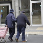 Dos ancians creuen un pas de vianants al barri de Balàfia.