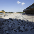 Acera levantada y maquinaria de obra en el solar de las torres. 