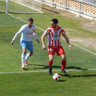Un jugador del Montsó protegeix l’esfèric davant la pressió defensiva d’un jugador local.