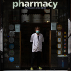 Un farmacèutic, ahir a les portes del seu establiment a Barcelona amb màscara.
