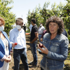 La consellera Jordà muestra una nectarina destrozada en un campo de Soses junto a la alcaldesa.