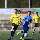 Un jugador del Lleida B porta la pilota davant de la pressió d’un defensa rival.