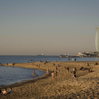 Desenes de persones a primera hora en una platja de Barcelona. Alguns prenen el sol tot i les normes.