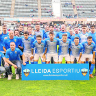 Los jugadores de un once titular del Lleida posan con aficionados antes de un partido.