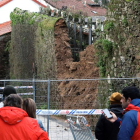 Curiosos observan el muro que causó la muerte de un hombre en Santiago al derrumbarse.