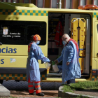 Un equipo de emergencias desinfecta sus elementos de protección después de atender una urgencia en una calle de Ávila
