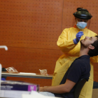Imagen de un sanitario haciendo la PCR a un joven en el centro cívico de Balàfia.