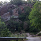 La carretera d’accés al nucli de les Llagunes i el pendent d’on cauen roques al fons.