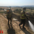 Dos bomberos remojando la zona quemada. 