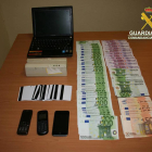 Imatge del material informàtic, les targetes, els mòbils i els diners confiscats als acusats.