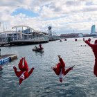Participantes disfrazados de Papá Noel se lanzan al agua.