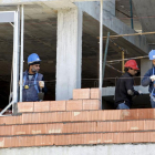 Tres trabajadores de la construcción, en la obra de un edificio de viviendas.