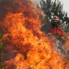 Un bomber intenta sufocar les flames a la localitat lusitana de Maçao.