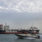 Una lancha iraní pasa junto a un barco en el estrecho de Ormuz. 