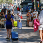 Diverses turistes caminen per la Rambla de Barcelona.