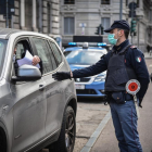 Control de la Policía italiana a un vehículo, ayer. Los agentes, con máscara, guardan las distancias.