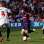Leo Messi, capità dels blaugranes i autor de tres dels quatre gols davant del Sevilla, prova de driblar el defensa local Simon Kjaer.