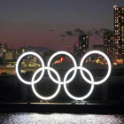Los aros olímpicos lucen de noche en la bahía de Tokio.
