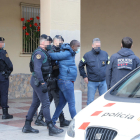 Traslado de uno de los detenidos a la salida del registro en un piso de la calle Bonaire de la ciudad de Lleida.