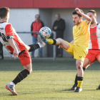 Un jugador del Almacelles pugna con un adversario por el control de un balón dividido.