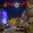 Un carrer decorat amb llums nadalencs i buit a Bellpuig.
