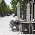 Cadires i taules de la terrassa d’un bar apilades a la rambla Ferran de Lleida.