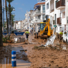 Unos vecinos de Alcanar trabajan para sacar el agua de su casa.