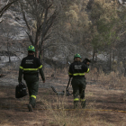 Imatge de dos agents rurals en una zona cremada.