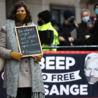 Una partidaria del fundador de WikiLeaks sostiene un cartel fuera del Tribunal Penal Central.