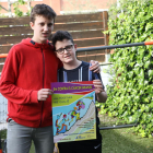 Pau Odina (a la derecha) junto a su hermano Manel, con el cartel de la carrera virtual solidaria. 