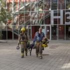 Dos bomberos saliendo ayer del edifico H3 donde hay el laboratorio en el que hubo la explosión. 
