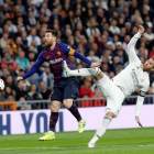 Messi rep una dura entrada de Sergio Ramos durant la disputa d’un clàssic.