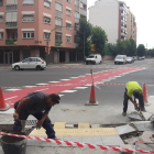 Dos operarios ultiman los preparativos del nuevo paso de peatones de la avenida de Les Garrigues.