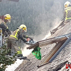 Bomberos sofocando las llamas originadas en una casa adosada. 