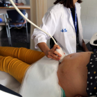 Una doctora hace una ecografía a una mujer embarazada, que participa en el ensayo clínico de la vacuna de Pfizer de la covid-19 en este colectivo, en el Hospital Vall d'Hebron