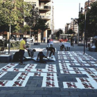 Activistas de Òmnium Lleida preparando el mosaico ayer por la mañana en la plaza Pau Casals. 
