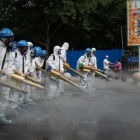 Operarios desinfectan una calle en Pekín para prevenir contagios.