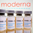 Viales con un adhesivo que dice 'COVID-19 / Vacuna contra el coronavirus / sólo para inyección' y una jeringa ante el logotipo de Moderna