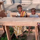 Pupitres escolars amb el nom de Torre-serona gravat en una escola de l'Àfrica occidental
