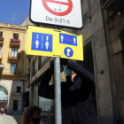 Un operari instal·la un cartell informatiu a la plaça Sant Francesc.