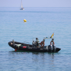 Agents de la Guàrdia Civil, ahir, durant l’examen de l’artefacte trobat a la costa de Badalona.