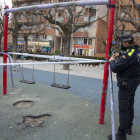 Un agente de la policía de Tàrrega precinta un parque infantil tras decretarlo el ayuntamiento.