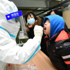Un sanitari realitza una prova PCR a un ciutadà a la Xina.