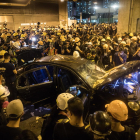Un coche destrozado durante los enfrentamientos entre policía y manifestantes en Hong Kong.