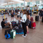 Varios pasajeros esperando ayer frente a los mostradores de Vueling en el aeropuerto de El Prat. 