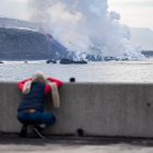 Una persona observa una colada de lava en su llegada al mar.